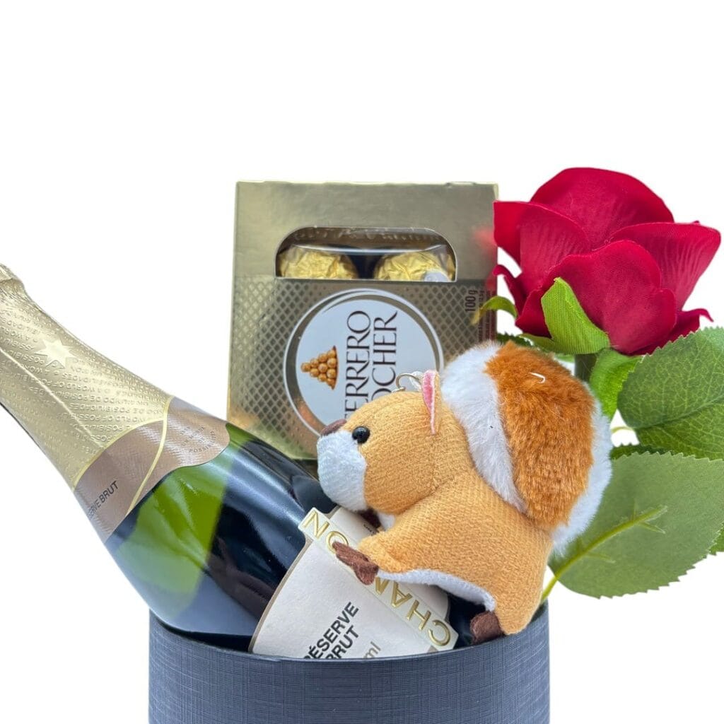 Chaveiro encima do mini champagne chandon, flor e ferrero rocher