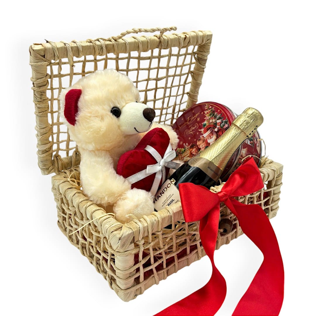 CEsta palha com pelúcia de ursinho segurando coração, espumante chandon e caixa de biscoito amenteigado natal