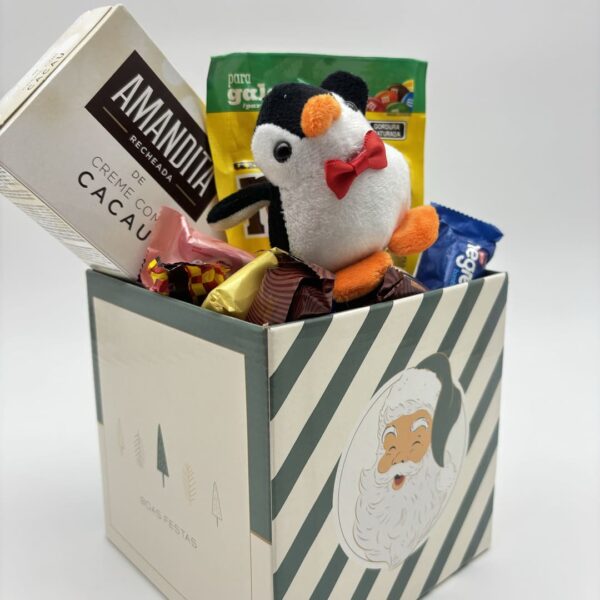 cachepote verde e bege com paipai noel com chaveiro de pinguim, m&m, amandita, caixa de doce variado vista diagonal